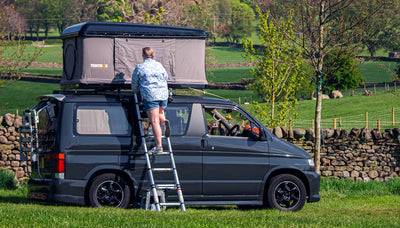 Person climbing up ladder into TentBox Classic roof tent